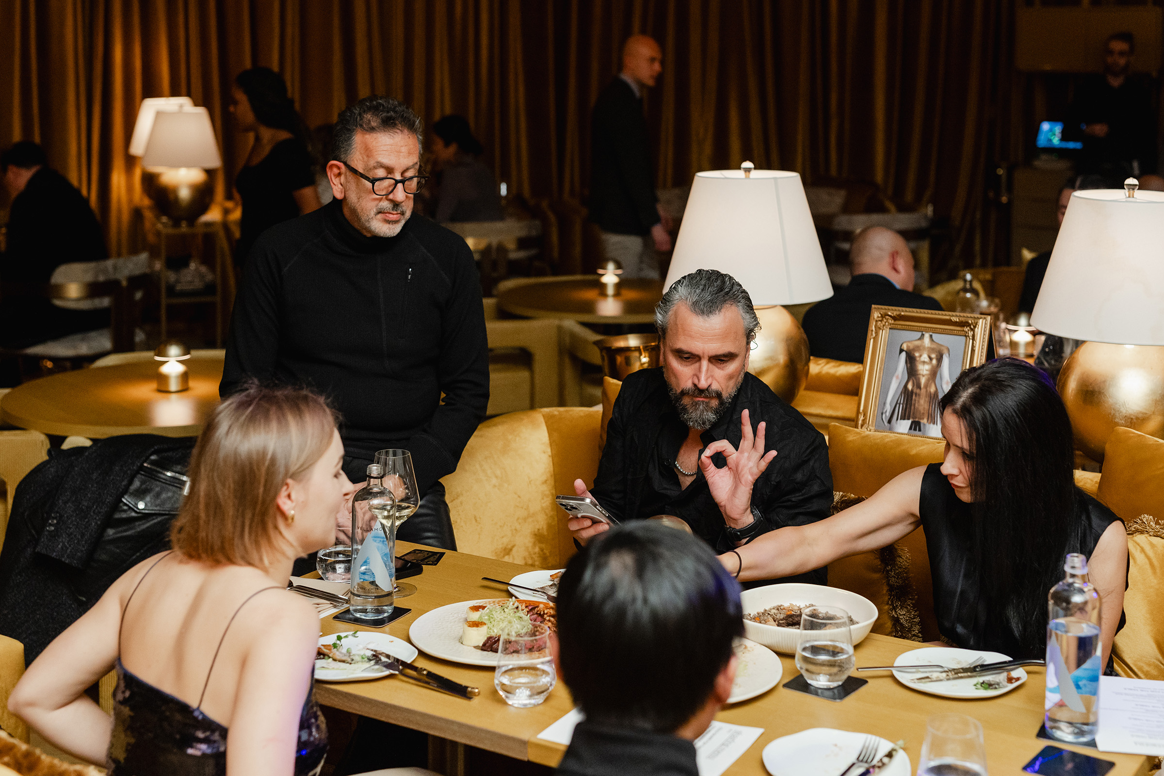 A group of people engaged in content creation at a table in a restaurant.
